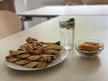 Das Bild zeigt Gebäck aus Blätterteig und Käse, das die Schülerinnen gebacken haben, und einen Cocktail, den die Klasse gemischt hat.